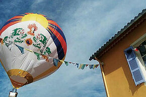 Photo d'une montgolfière au couleur du Tibet et du Dalaï-lama à ue fenêtre et du d
